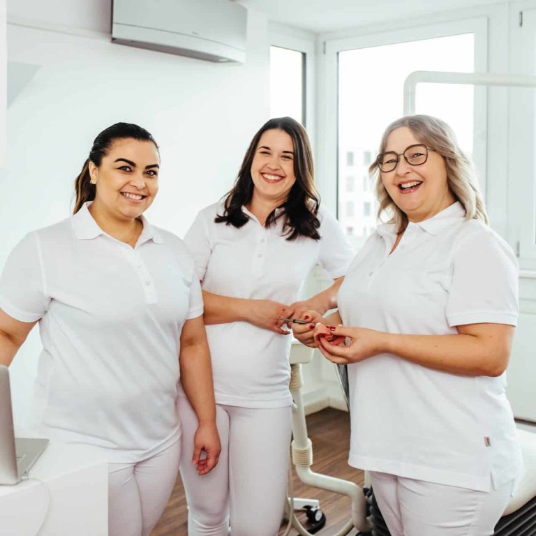 Drei lächelnde Prophylaxeassistentinnen in Zahnarztpraxis in Darmstadt.